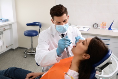Professional dentist working with patient in clinic