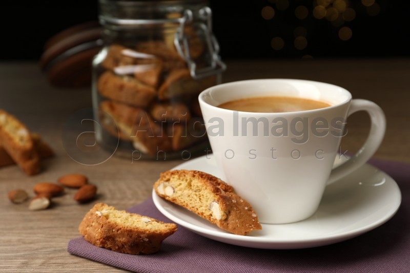 Tasty cantucci and cup of aromatic coffee on wooden table. Traditional Italian almond biscuits