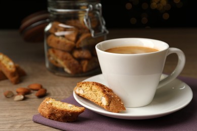 Photo of Tasty cantucci and cup of aromatic coffee on wooden table. Traditional Italian almond biscuits