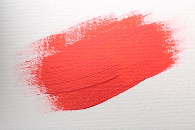 Sample of red paint on white background, top view