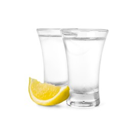 Photo of Shot glasses of vodka with lemon slice on white background