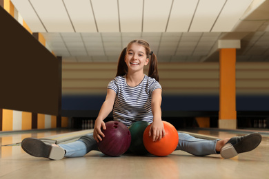 Photo of Preteen girl with balls in bowling club