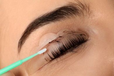 Young woman undergoing eyelash lamination and tinting, closeup
