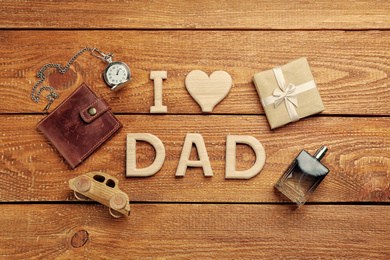 Phrase I LOVE DAD made of wooden letters and male accessories on wooden table, flat lay. Happy Father's Day