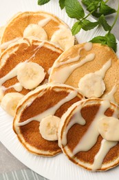 Tasty pancakes with sliced banana served on grey table, closeup