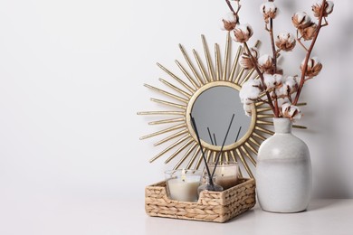 Home decor and vase with cotton branches on table against white background. Space for text