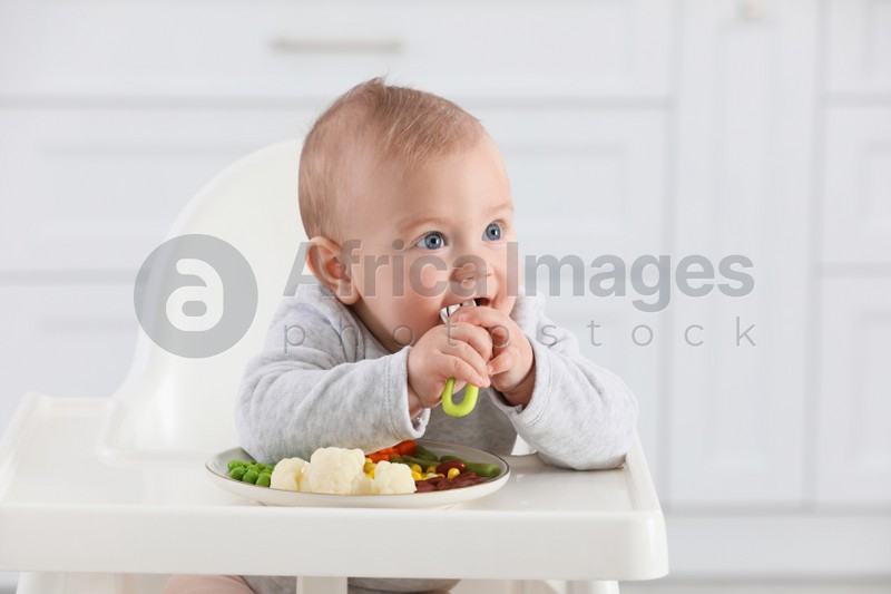 Cute little baby eating healthy food at home