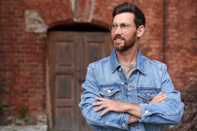 Photo of Handsome bearded man with glasses looking away outdoors. Space for text
