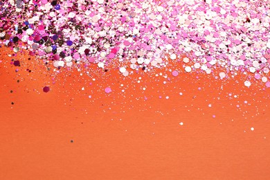 Shiny bright pink glitter on coral background. Space for text