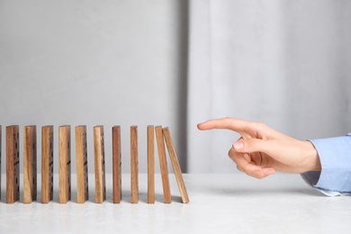 Woman with wooden dominoes at white table, closeup