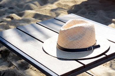 Photo of Stylish straw hat on wooden table outdoors, space for text