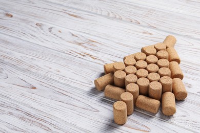 Photo of Christmas tree made of wine corks on white wooden table. Space for text