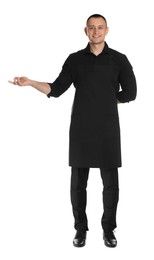 Full length portrait of happy young waiter in uniform on white background