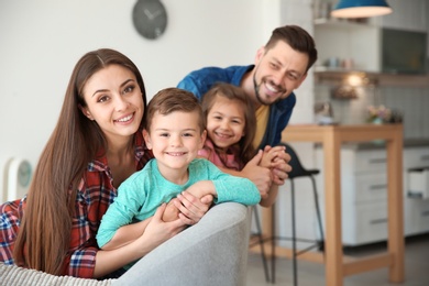 Happy family with cute children on sofa indoors