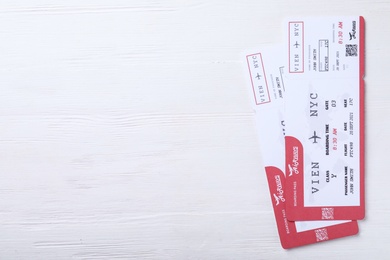 Tickets on white wooden table, flat lay with space for text. Travel agency concept