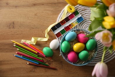 Flat lay composition with bright painted Easter eggs on wooden table