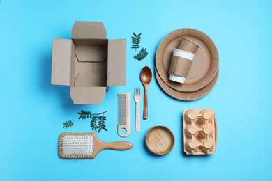 Different eco items on light blue background, flat lay. Recycling concept