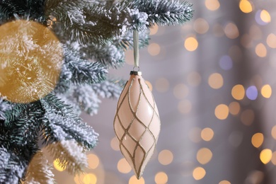 Christmas tree decorated with holiday bauble against blurred lights, closeup