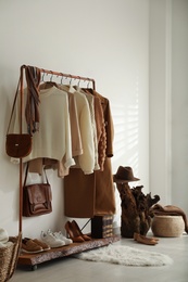 Modern dressing room interior with rack of stylish shoes and women's clothes
