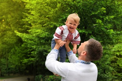 Man with his baby in national clothes outdoors
