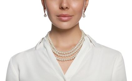 Young woman wearing elegant pearl jewelry on white background, closeup