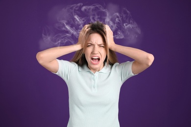Stressed and upset young woman on violet background