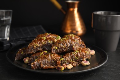 Delicious baklava with pistachio nuts on black table