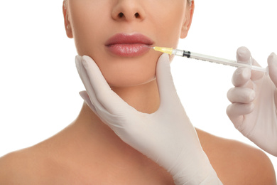 Woman getting lip injection on white background, closeup