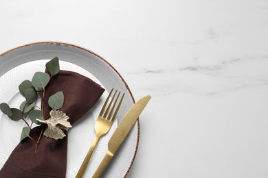 Photo of Stylish table setting with cutlery and eucalyptus leaves, top view. Space for text