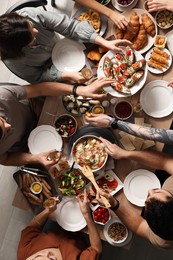 Group of people having brunch together at table indoors, top view