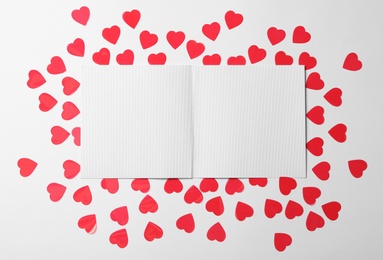 Blank card and paper hearts on white background, flat lay with space for text. Valentine's Day celebration