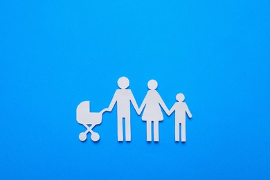 Paper family cutout on light blue background, top view. Insurance concept