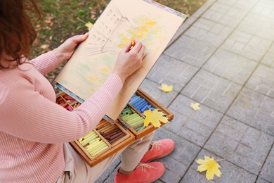 Woman drawing with soft pastels on street, closeup