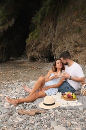 Photo of Happy young couple having picnic on beach