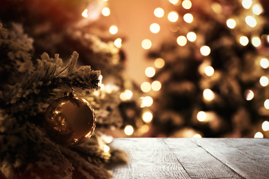 Beautiful Christmas tree and wooden surface against blurred background