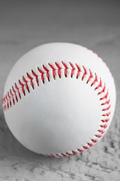 Photo of Baseball ball on grey wooden table, closeup view