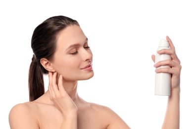 Young woman applying thermal water on face against white background. Cosmetic product