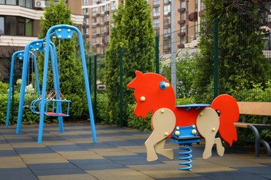Photo of Empty horse spring rider on children's playground in residential area, space for text