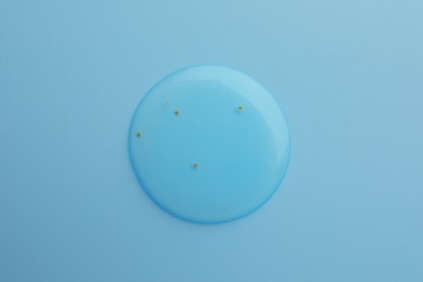 Photo of Sample of face gel on light blue background, top view