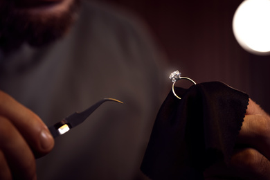 Jeweler working with ring on blurred background, closeup