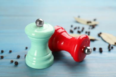 Salt and pepper shakers on turquoise wooden table, closeup. Spice mill