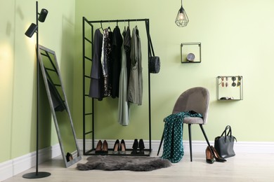 Modern dressing room interior with clothing rack, chair and mirror