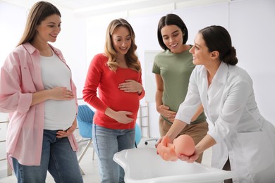 Pregnant women learning how to bathe baby at courses for expectant mothers indoors