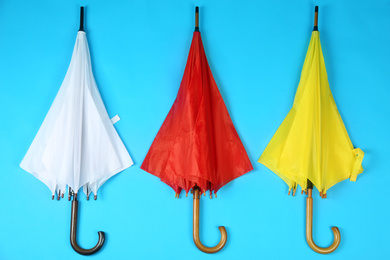 Beautiful colorful umbrellas on blue background, flat lay