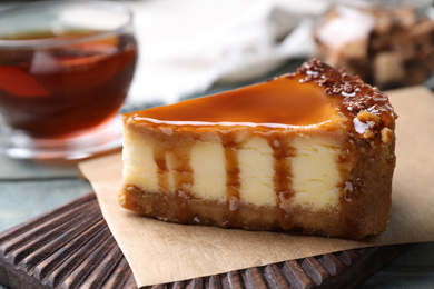 Piece of delicious cake with caramel on board, closeup