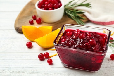Cranberry sauce on white wooden table, space for text