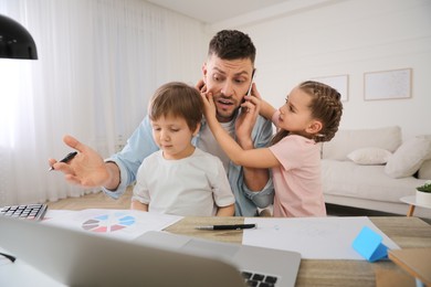 Overwhelmed man combining parenting and work at home