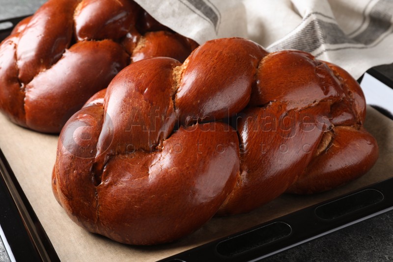 Homemade braided bread on grey table, closeup. Traditional challah