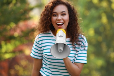 Photo of Happy African-American woman with megaphone outdoors. Meeting leader