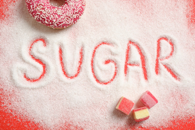 Photo of Flat lay composition with sweets and word SUGAR on red background